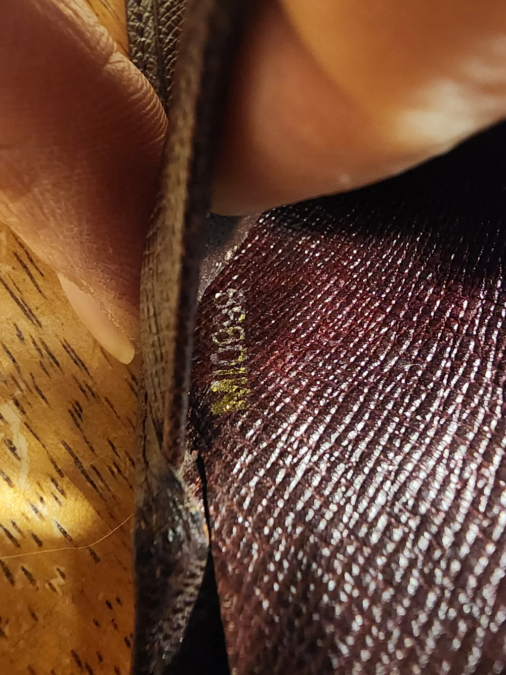 burgandy Louis Vuitton Taiga leather bifold wallet featuring a debossed LV